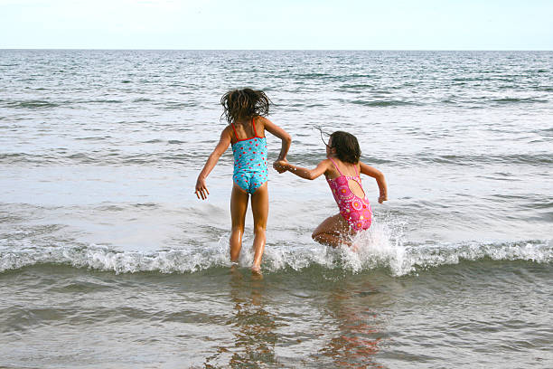 istock Two girls jumping waves in the Great Lakes 151544585