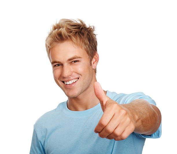 Surprised young guy with funny face in yellow T-shirt pointing finger to left, white isolated background. Shocked amazed face of young man, portrait of excited male