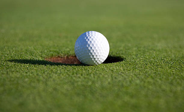 istock Golfball on the verge of falling in. 151546573