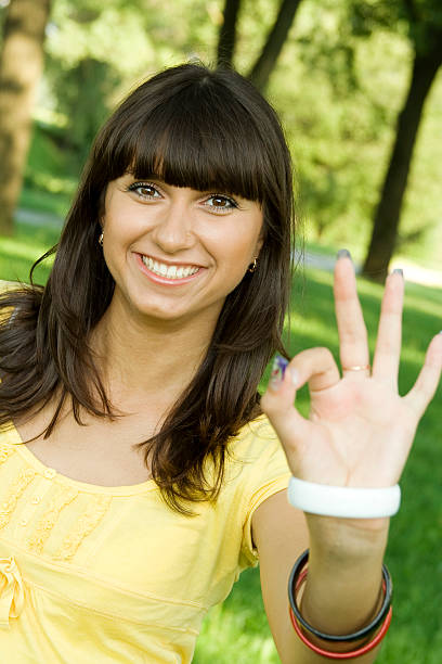 молодая женщина знак ок - hand sign human hand ok sign grass стоковые фото и изображения