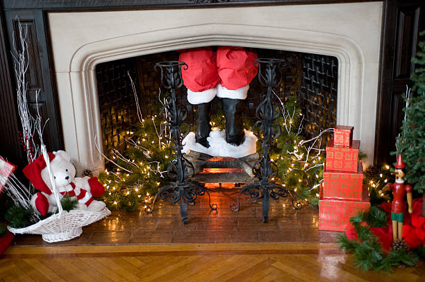 Santa Claus is Coming to Town Santa's pants and boots coming down the chimney with Christmas decorations around chimney photos stock pictures, royalty-free photos & images