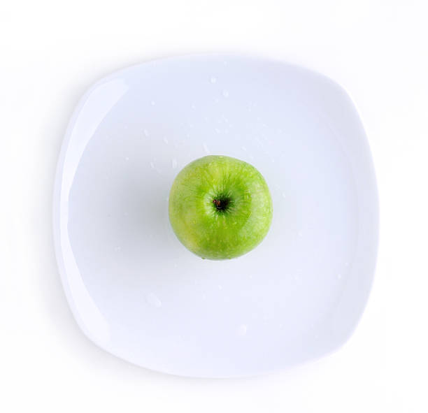 Green apple in the plate stock photo
