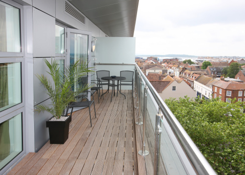 Modern high-rise apartment balcony with views over town