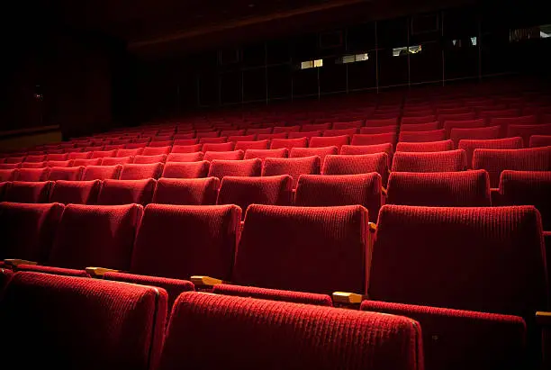 Photo of Empty theatre with red seats in low light