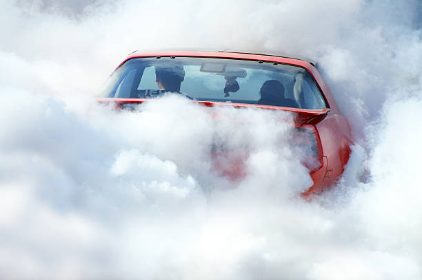 American car in smoke Car is in the smoke while drifting tyres. The smoke covers almost the whole car. This photo was taken on an American auto festival. smoking issues photos stock pictures, royalty-free photos & images