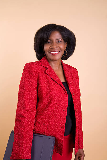 Business woman wearing red suit on orange background stock photo
