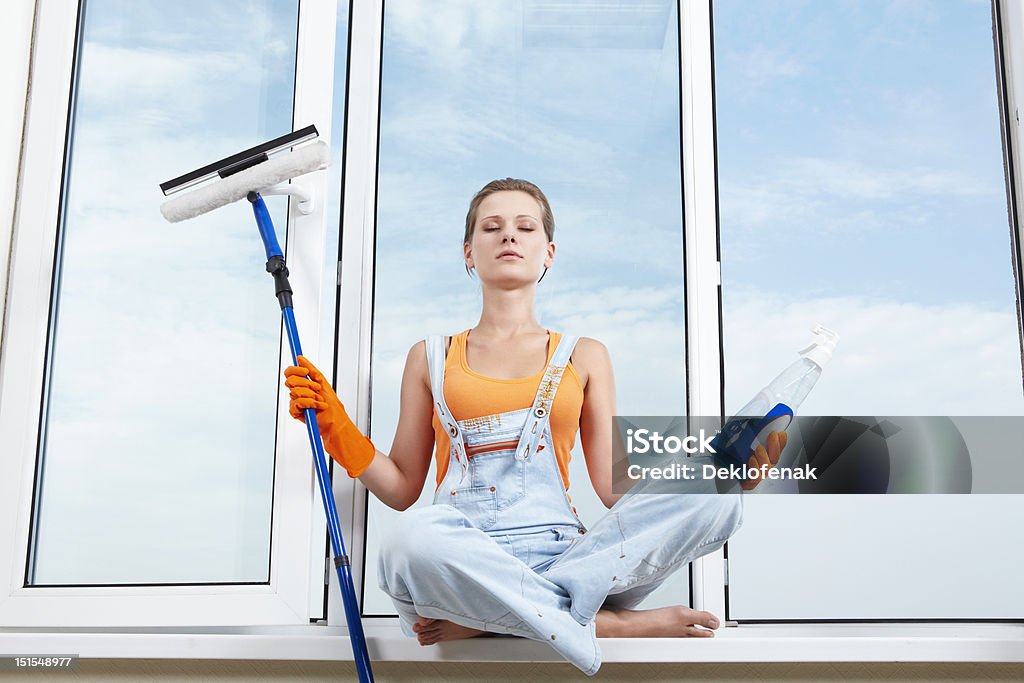 Relax Attractive girl with detergents in the lotus position on the windowsill Adult Stock Photo