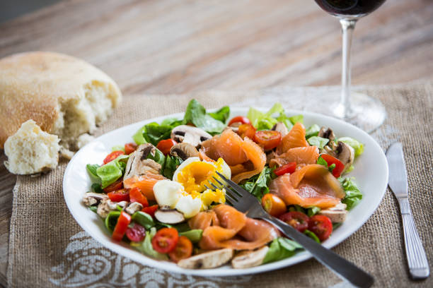 Smoked salmon salad, poached egg, green leaves and tomato