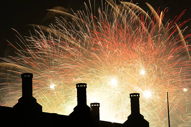 Silhouettes of chimneys with a background fireworks display stock photo
