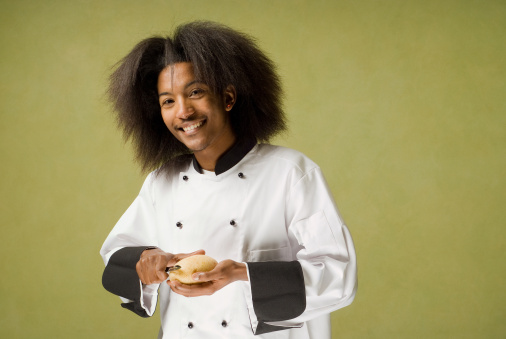 Happy Young African American Chef Peeling a Potato