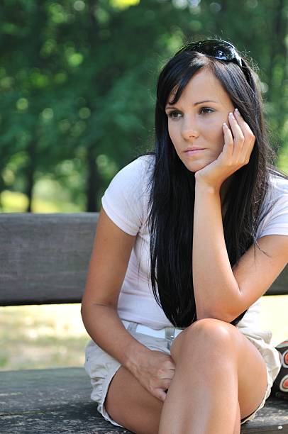 istock Young pensive woman siting on bench 151550041