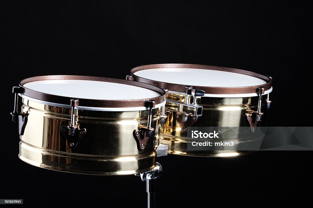 Timbales Isolated Against Black A set of gold brass timbale drums isolated against a black background in the horizontal format. Black Background Stock Photo