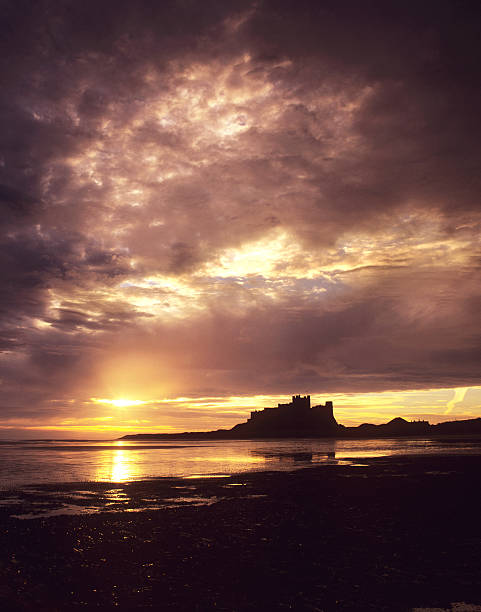 castillo de bamburgh bajo vehemente sky - bamburgh northumberland england beach cloud fotografías e imágenes de stock