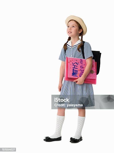 Foto de Menina Vestido Com Uniforme Segurando O Trabalho Escolar e mais fotos de stock de Menina