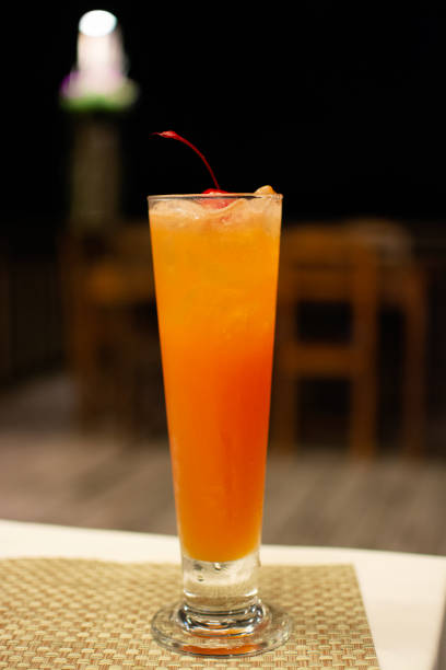 istock Fresh orange cocktail with ice and cherry standing on the table, alcoholic beverages 1515568370