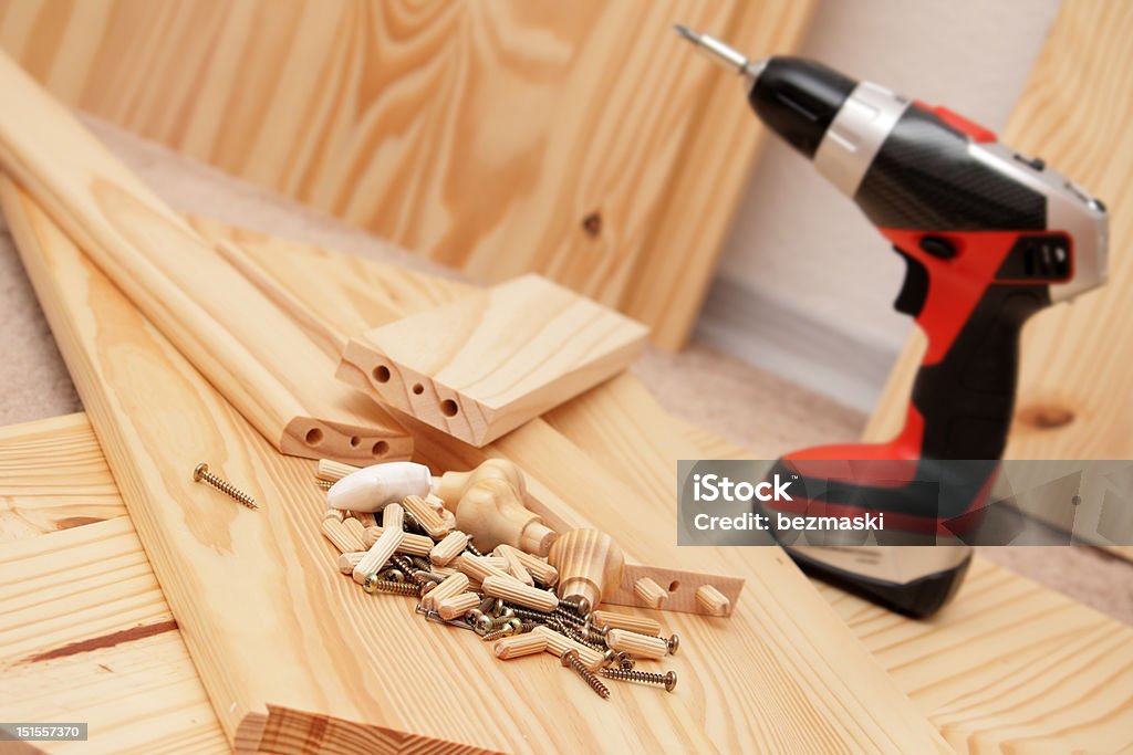 Mounting furniture with screwdriver Mounting wooden furniture with cordless screwdriver Art And Craft Stock Photo
