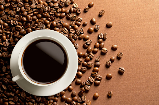 Roasted coffee beans with a white cup