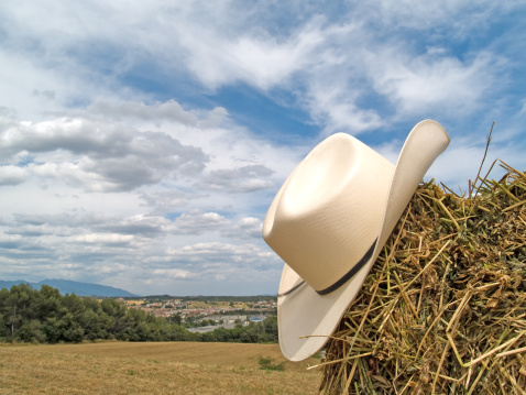 A white cowboy hat in the straw, in a clear blue sky