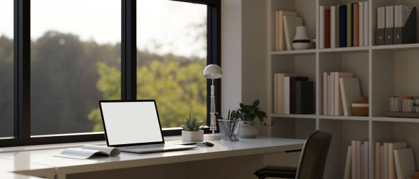 istock Close-up image of a modern workspace with laptop mockup on a table against the window 1515598085