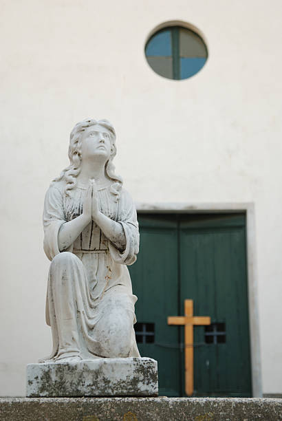 Statue of the Virgin Mary prays for those resting in the cemetery in the Cinque Terre region of Italy.
