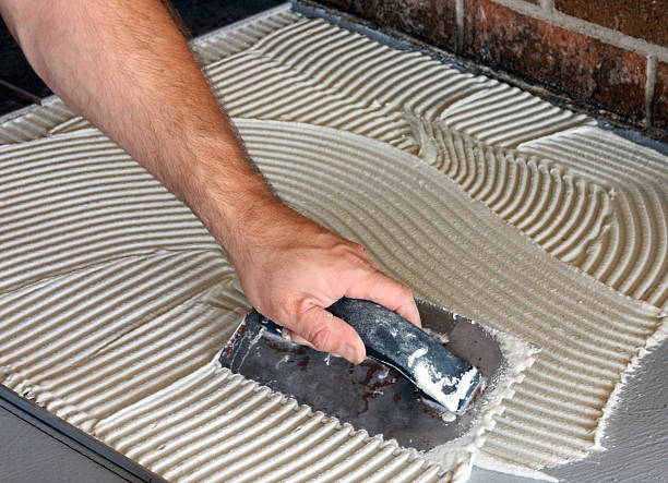 istock Hand spreading mortar for laying new tile floor 151560190