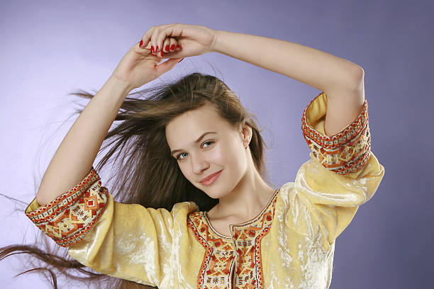 Beautiful young woman in russian handmade costume. Studio shot