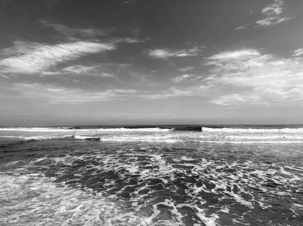 Playa de Xago near Aviles in Asturias, with large waves rolling in onto the sandy beach, black and white 35mm.
