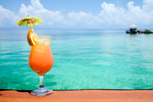A refreshing tropical drink, with an island paradise in the background