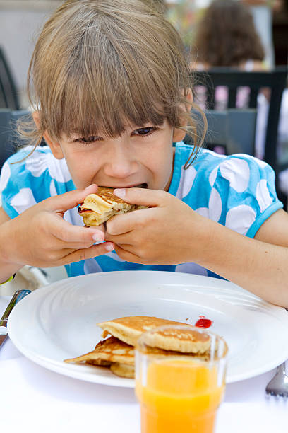 istock little cute girl eat pancake 151563048