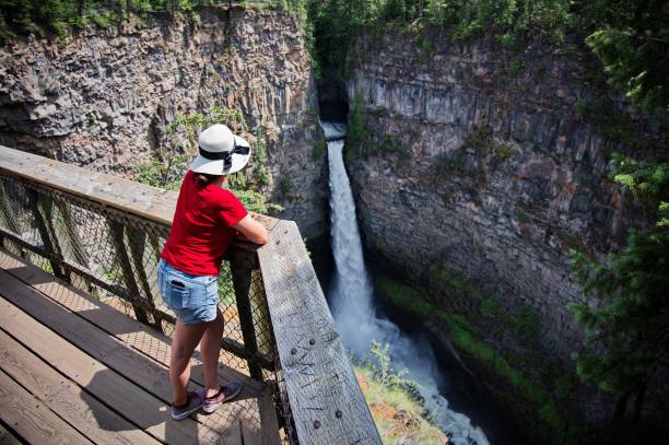 Mature woman railing above the scenic waterfall in Canada BC