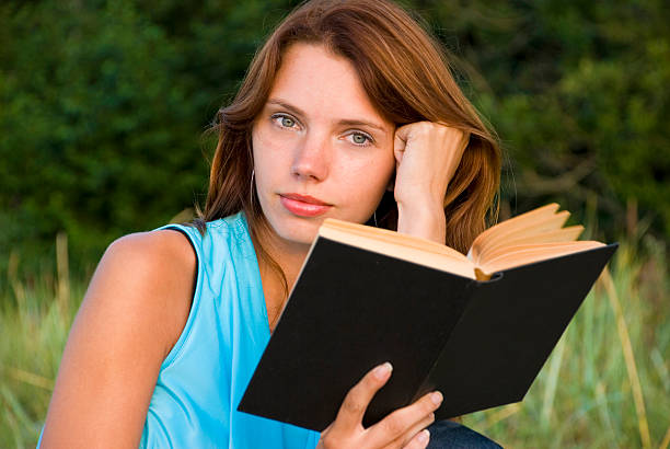 istock Young woman reading a book 151564509