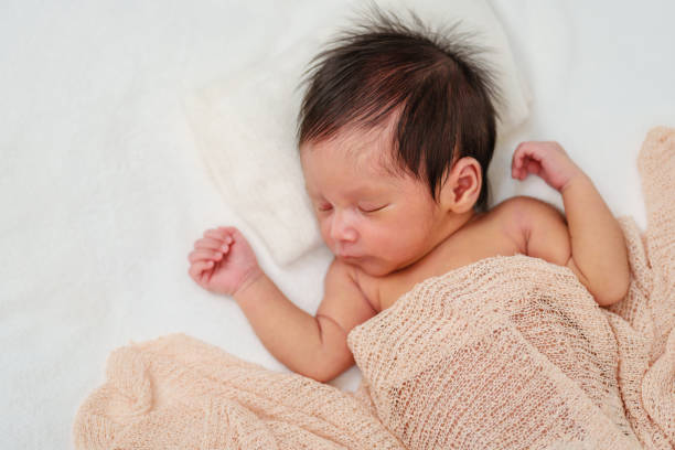 istock newborn baby sleeping in blanket on bed 1515649430