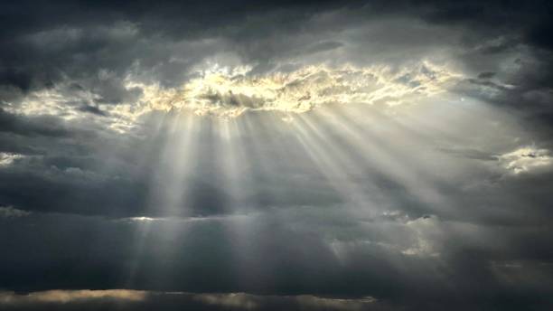 istock Full Frame Cloudscape of Sunlight Beaming Through Illuminated Clouds in Moody Gray Skies • Natural Background with Copy Space 1515666703