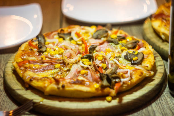 Yummy italian homemade pizza entering a wood-fired oven for baking. Yummy italian homemade pizza entering a wood-fired oven for baking. san rafael california stock pictures, royalty-free photos & images