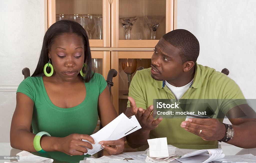 Jeune couple ethniques en table émerveillé par les factures - Photo de D'origine africaine libre de droits