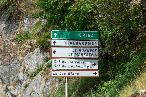 street sign with arrow in the Vosges region to EPINAL, GERARDMER, LE HOHNECK, LE LAC BLANC AND COL DU Bonhomme in France