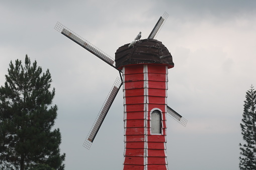 windmill with red buildings and sky and clouds background