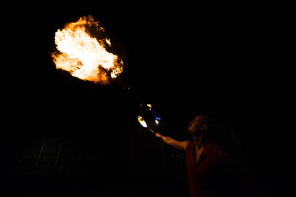 istock Street Performer Fire Breather Blowing on Torch 151578105