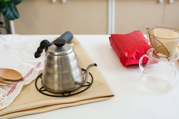 Kettle for drip coffee on the table Prepare to make fresh coffee in the morning. On the table was a cup and a cup of hot water. Waiting for the butler to brew coffee