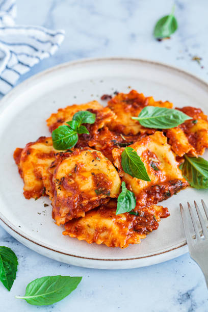 istock Ravioli with ricotta, tomato sauce and basil, white marble background. 1515878175