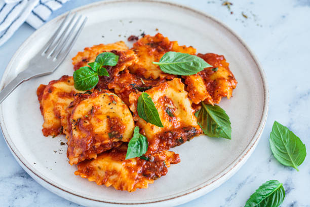 istock Ravioli with ricotta, tomato sauce and basil, white marble background. 1515878199