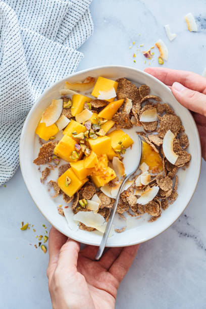 istock Wholewheat breakfast cereals with banana, coconut and mango. Vegan breakfast concept. 1515881865