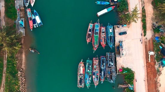 Aerial top view of Uganda harbor with boats by coast. Cinematic beautiful drone shot of Uganda harbor with boats by coast in daytime. Come on vacation to Uganda harbor to fish on boats by coast.