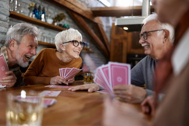 istock Happy senior friends enjoying while playing cards at home. 1515907076