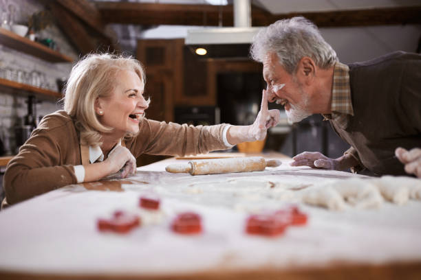 istock Cheerful mature couple having fun while making a cake in the kitchen. 1515910750