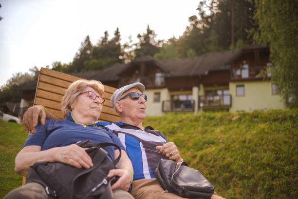 Happy and delighted seniors sitting on a bench and relaxing before heading to the Resort