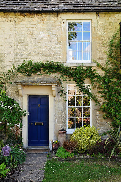 Stone cottage with Windows and blue door stock photo