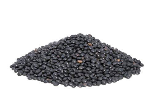 Pile Black Beluga Lentils isolated on white background. Lentils are rich in protein, carbohydrates, fiber, and low in fat.