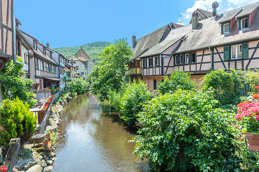 picturesque colorful view of half-timber buildings at a small creek in the village of Kaysersberg in Vosces region.