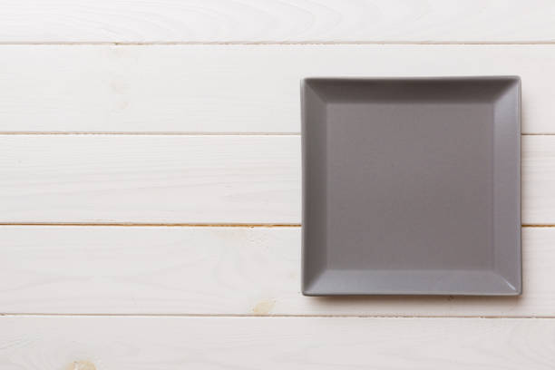 istock Top view of empty square plate on wooden background. Empty space for your design 1516014472